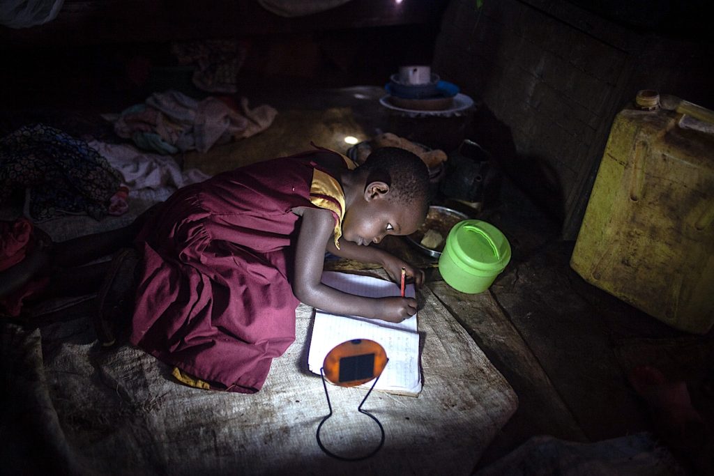 child doing schoolwork using solar light