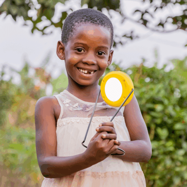 Student with her new solar light at Lights 4 Learning project